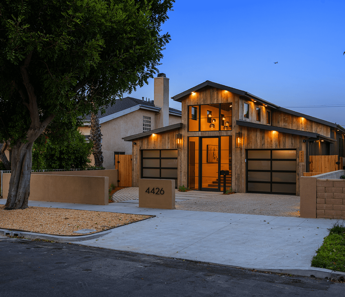 Modern house with illuminated exterior at dusk.