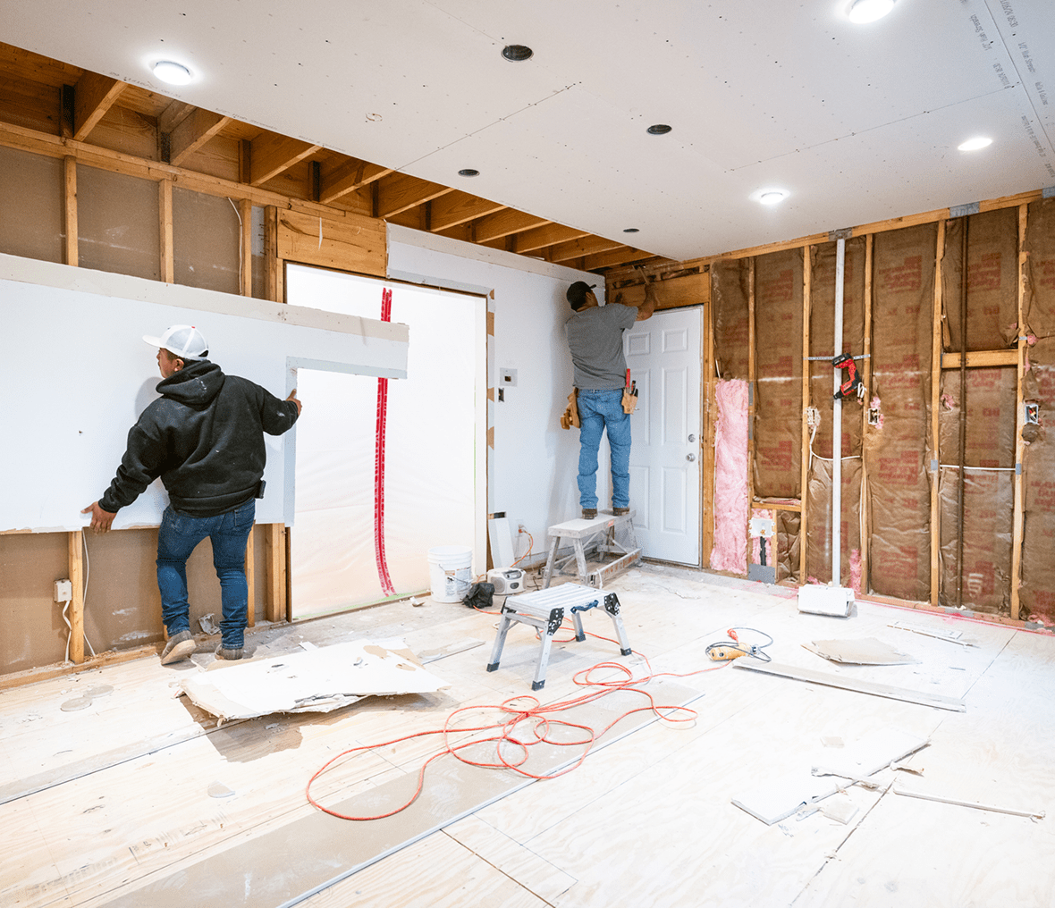 Home renovation with workers installing drywall.