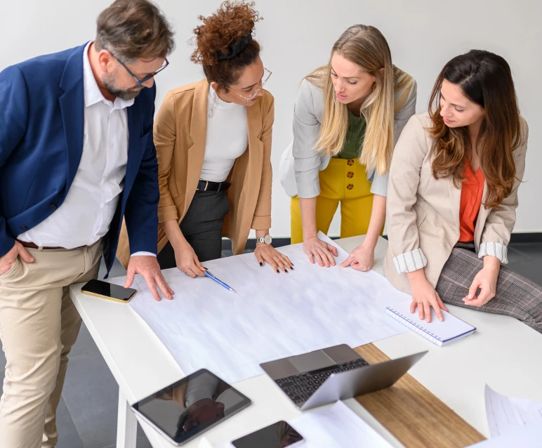Team collaborating over a large desk map.